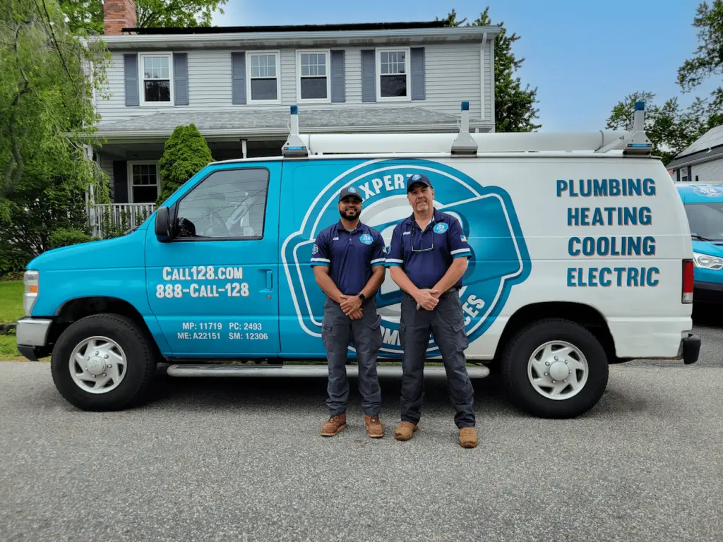 128 Home Services technicians standing in front of a service van